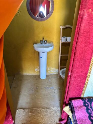 a small bathroom with a sink and a mirror at Chigaga Luxury Camp in Mhamid