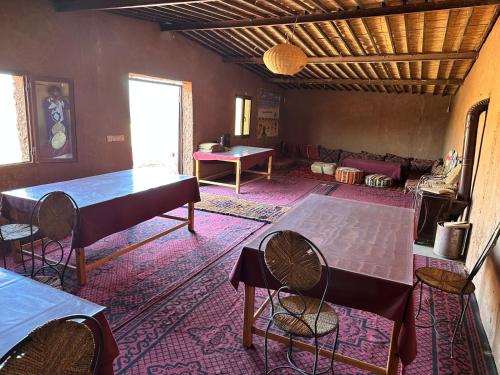 a living room with tables and chairs and a couch at Chigaga Luxury Camp in Mhamid