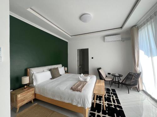 a bedroom with a large bed and a green wall at Casa-Pel Villa Grande in Palatswe