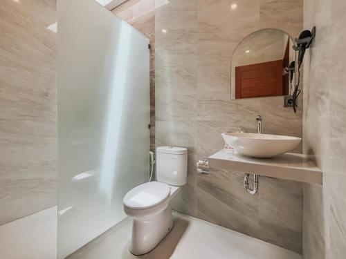 a bathroom with a toilet and a sink at Kerti Suite in Munggu