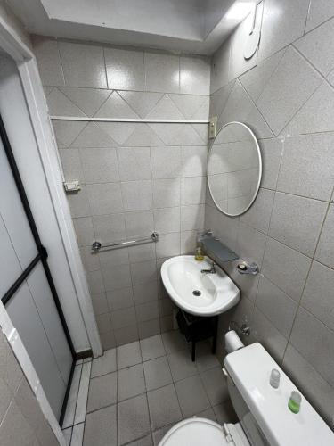 a bathroom with a sink and a toilet and a mirror at Relax en el Centro, Moderno Depto con AC y Estilo in Posadas
