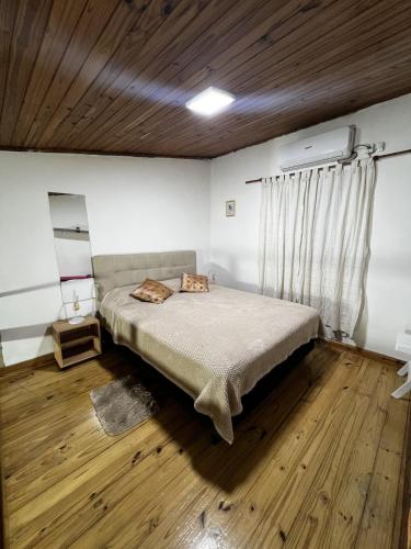 a bedroom with a bed and a wooden floor at Relax en el Centro, Moderno Depto con AC y Estilo in Posadas
