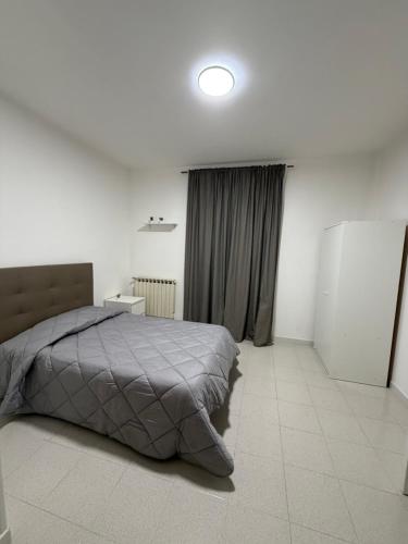 a white bedroom with a bed and a window at B&B Boffa in Buccino