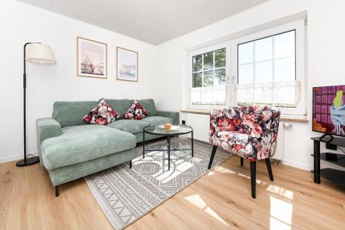 a living room with a couch and a chair at Ferienwohnung Sternstunde in Bensersiel