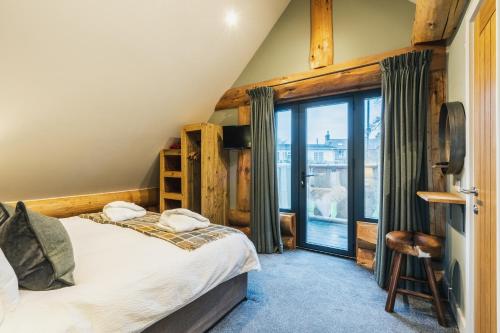 a bedroom with a bed and a balcony at Keepers Cabin in Ilkley