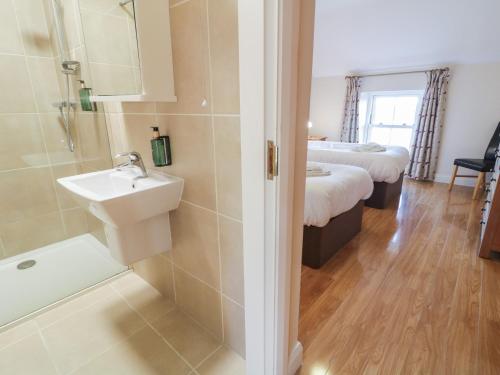 a bathroom with two beds and a sink and a shower at Finn Cottage in Strabane