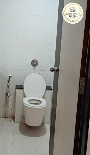 a bathroom with a white toilet in a stall at Hotel Shiv Sai in Shirdi