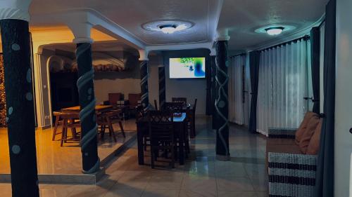 a dining room with chairs and a table and a screen at Kuri hotel Kampala in Kampala