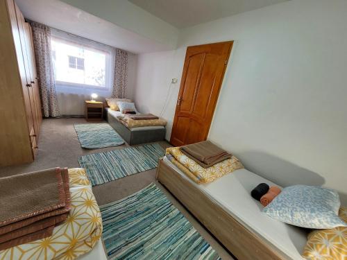 a living room with two beds and a window at Mandula Apartman in Szeged
