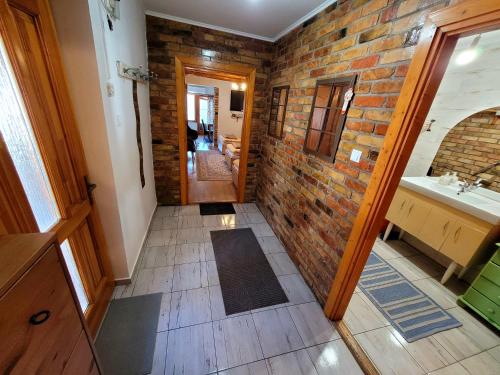a bathroom with a brick wall and a sink at Mandula Apartman in Szeged