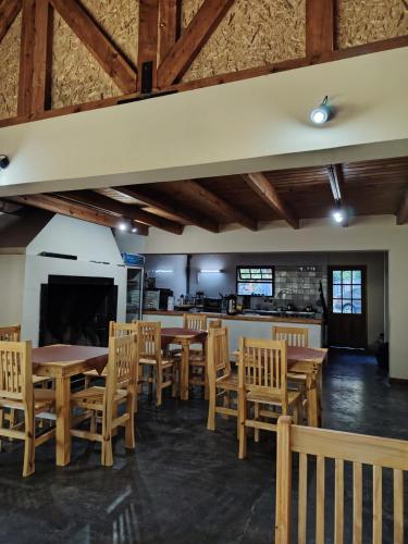 a dining room with wooden tables and chairs at Bosque Hostel in Villa Traful