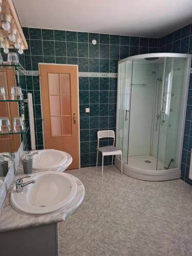 a bathroom with two sinks and a glass shower at Penzion Borlitz in Pohořelice