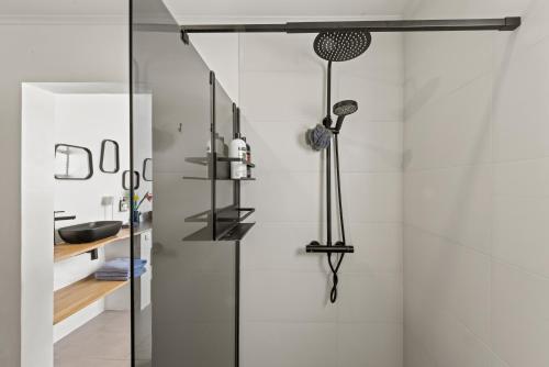 a bathroom with a shower with a glass door at Saint Joris a tiny Boutique Resort in Willemstad