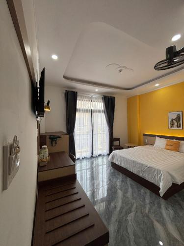 a bedroom with a bed and a yellow wall at Spring II Hotel in Ấp Bình Hòa (1)