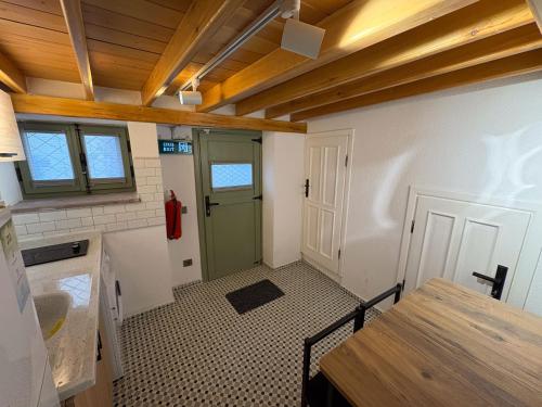 a kitchen with a green door and a tile floor at Macaron The Pure Guest Houses in Ayvalık