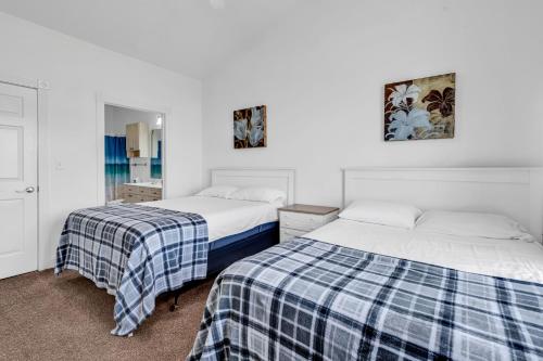 two beds sitting next to each other in a bedroom at Myrtlewood by Monarch Rentals in Myrtle Beach