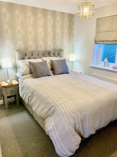 a bedroom with a large bed and a chandelier at The Coach House, Cleobury Mortimer in Cleobury Mortimer