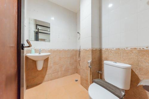 a bathroom with a toilet and a sink at RedDoorz Plus at Buah Batu in Bandung