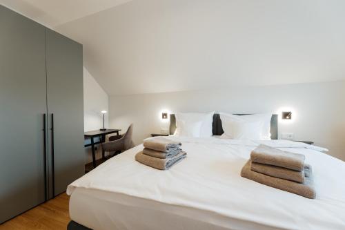a bedroom with a white bed with towels on it at Ferienhaus HeimatLay in Mörsdorf
