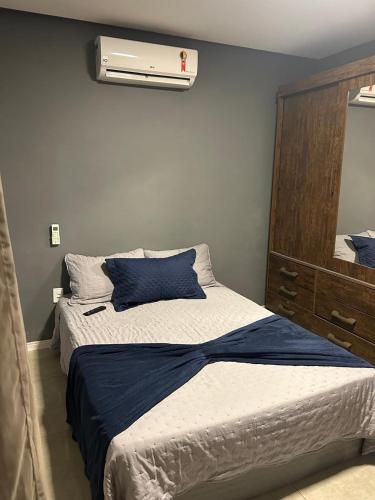 a bedroom with a bed with a blue comforter at Búzios Family House in Búzios