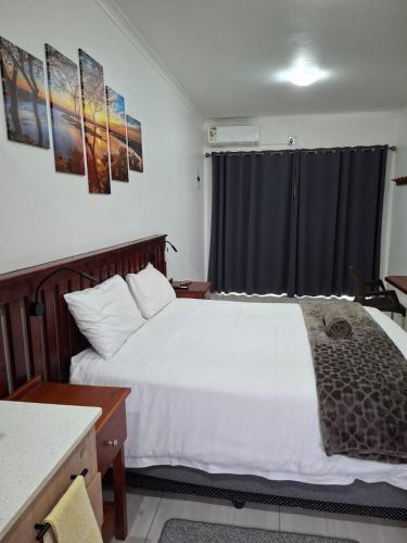a bedroom with a white bed and a window at Unit 17 Sunbird Self-Catering in Richards Bay