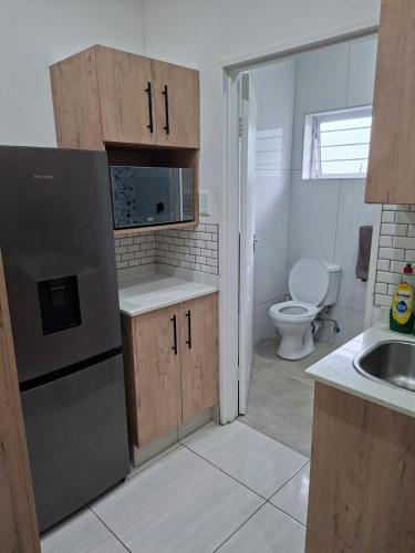 a small kitchen with a sink and a refrigerator at Unit 17 Sunbird Self-Catering in Richards Bay