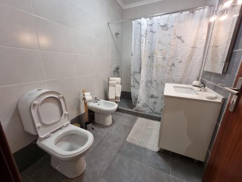 a bathroom with a toilet and a sink and a shower at Sunny Sunset House in Ponta do Pargo