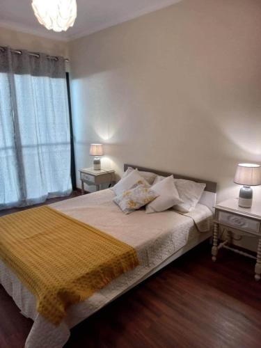 a bedroom with a large bed with two tables and two lamps at Sunny Sunset House in Ponta do Pargo