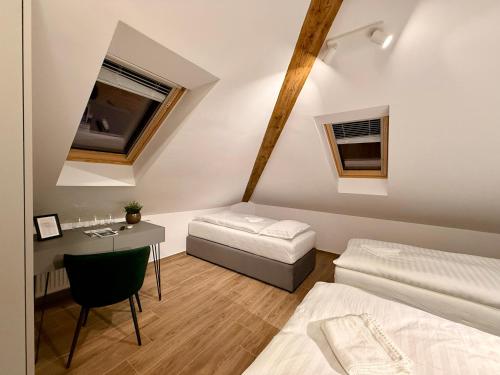 a bedroom with two beds and a desk and a table at Vila Vladorena in Požega