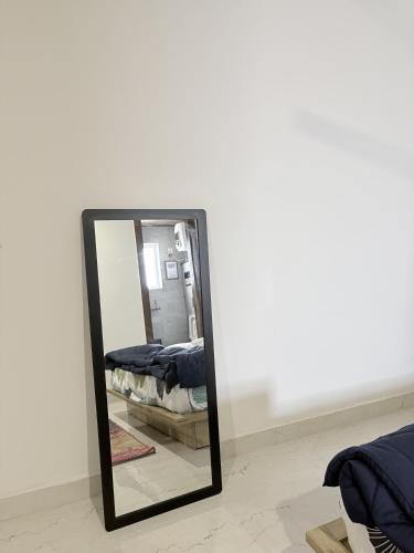 a mirror in a room with a bed at B&A Stays in Dehradun