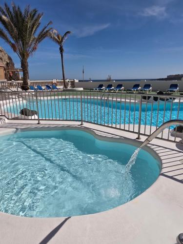a pool with a hot tub with a water fountain at Estrella y mar in La Estrella