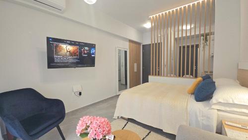a bedroom with a bed and a tv on the wall at Alfa-Central Luxury Condo by Optimum Link in Katerini