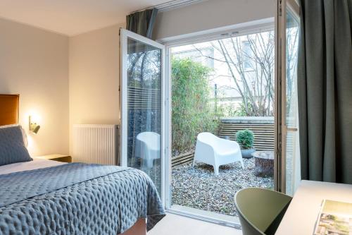 a bedroom with a bed and a sliding glass door at Key Inn serviced residences Belair in Luxembourg