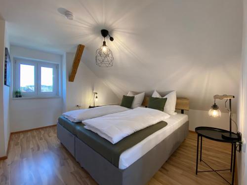 a bedroom with a large bed with a ceiling at Modernes 3-Familienhaus im Allgäu in Erkheim