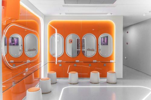 an orange exhibit with white stools in a room at SilMiCore Hostel in Shanghai