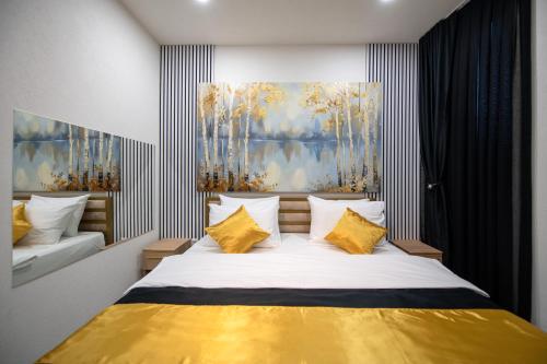 a bedroom with a large bed with yellow pillows at Hotel Centar Sanski Most in Sanski most