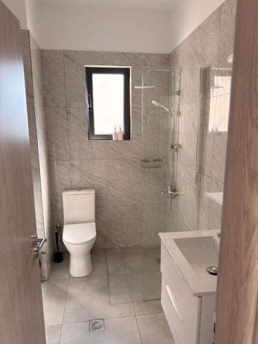 a bathroom with a toilet and a shower and a sink at Vana's Apartments in Sarandë