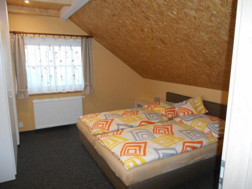 a bedroom with a bed and a window at Penzion Gerhard Klíny in Klíny