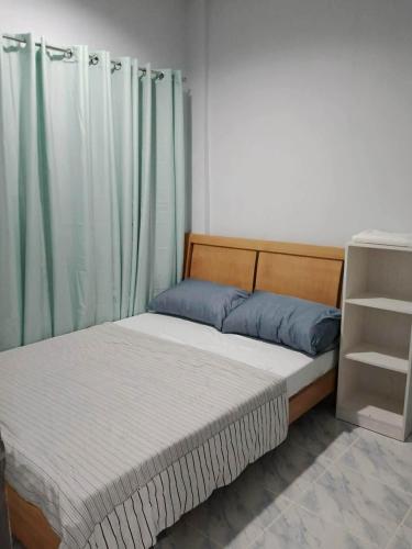 a bedroom with two beds with green curtains at Loida and Juns Homestay in Butuan