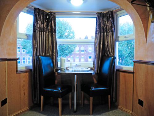 a dining room with a table and chairs and a window at Cricklewood Lodge Hotel in London