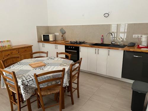 a kitchen with a table and chairs and a kitchen with a sink at Loue rez de maison 3mn de la plage in Canly