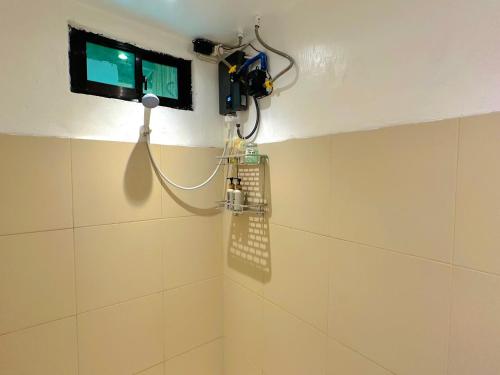 a shower in a bathroom with a tv on the wall at El Nido's View in El Nido