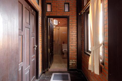 a hallway with a door and a toilet in a room at RedDoorz @ Cilandak Timur in Jakarta