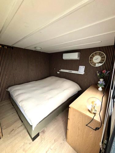 a small bedroom with a bed and a table at De Polderhoeve in Heerhugowaard
