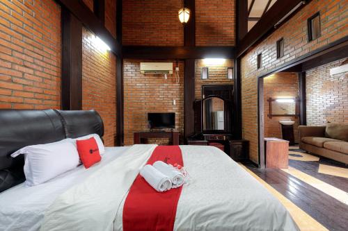 a bedroom with a large bed in a brick wall at RedDoorz @ Cilandak Timur in Jakarta