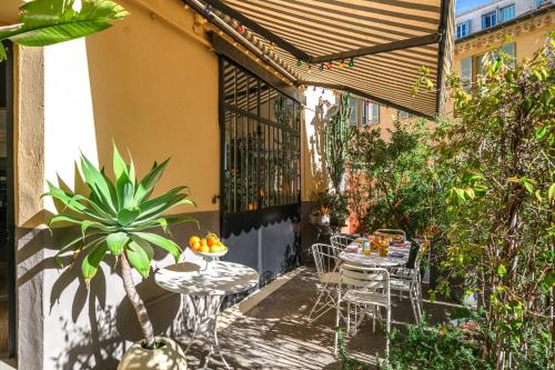 an outdoor patio with tables and chairs and a fence at Maison Nice - Plage 300m - Parking in Nice
