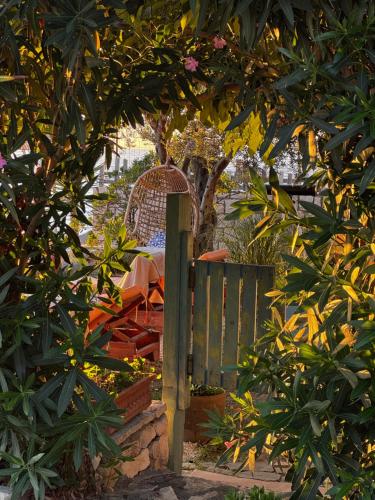 a garden with a table and a fence and trees at Kallmi View - Nature Retreat on the Albanian Adriatic Coast in Durrës