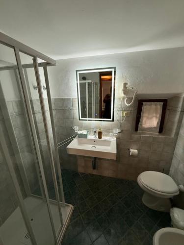 a bathroom with a sink and a toilet and a mirror at B&B Il Pettirosso di Siena in Siena