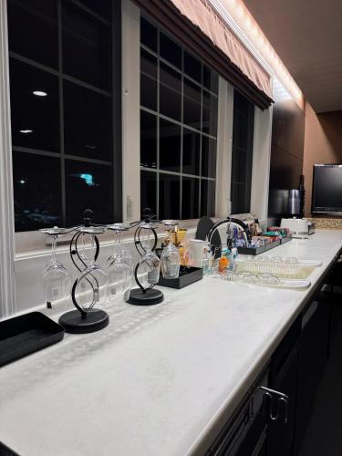 a kitchen counter with wine glasses on it at BIEI TERRACE 2nd Floor - 2F専用独立玄関 - 2F占有127平米2LDK - 大型バスルーム, 85型スマートTV, 無料Wi-Fi -駅前通り景観条例指定地区 in Biei