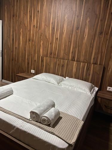 a bed with two towels and two pillows on it at stefanias apartment in Tirana